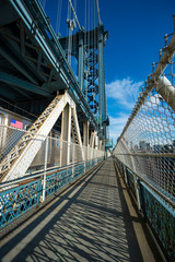Abstract afternoon view of shadows on the walkway as a subway train passes on the Manhattan Bridge in New York City, USA