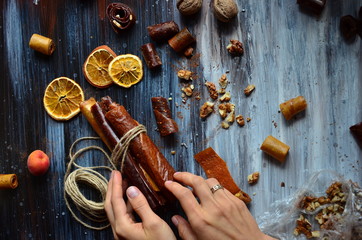 Pastila on a dark background, a composition of dried fruit, with hands