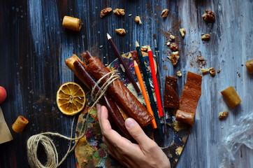 Pastila on a dark background, a composition of dried fruit, with hands