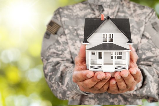 Soldier Holding a Model of House