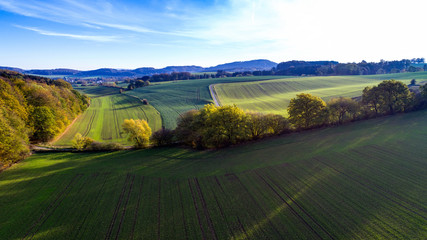 Blauer Himmel über Feld und Wald