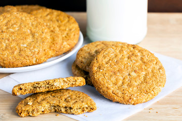 Homemade shortbread cookies made of oatmeal are stacked with glass bottle of milk on wooden background. Concept food healthy snack for enjoy in holiday with copy space for text.