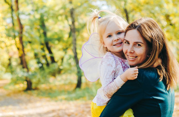 Mother and little daughter playing together in a park