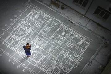 Woman engineer thinking over his plan. Mixed media