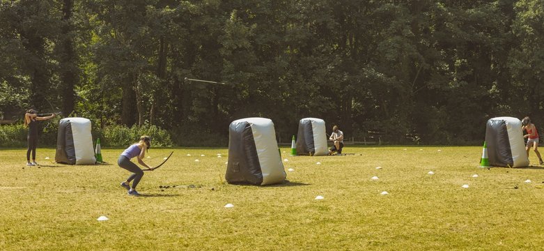 Man and women practicing archery at boot camp