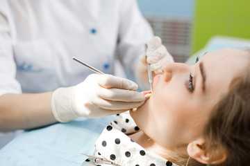 Dentist examines the patient's mouth close-up