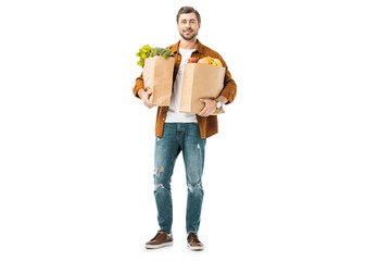 young man holding shopping bags full of products isolated on white