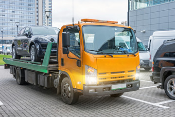 Hatchback car loaded onto a tow truck ready for transport.