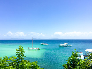 Fototapeta premium Caribbean sea with turquoise water, some boats and blue sky and 