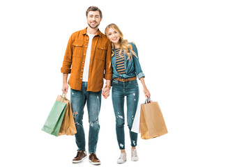 cheerful couple holding colorful shopping bags isolated on white