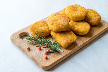 Homemade Crispy Chicken Nuggets with Rosemary and Cranberries on Wooden Board.