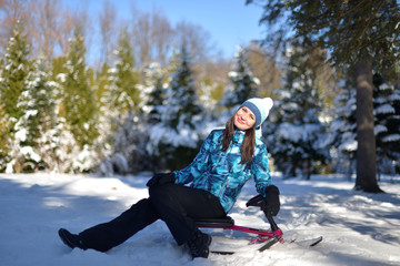 Fototapeta na wymiar A young woman walks in a snowy forest on a Sunny winter day.