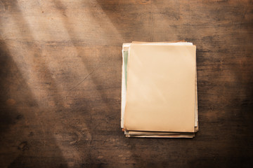 Old documents in blank on a old wooden desk, with by the window type light coming in. Ready for inserting your message or text.