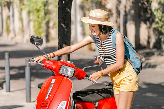 Girl friver near the red moto scooter