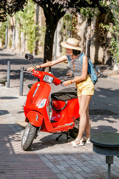 Girl friver near the red moto scooter