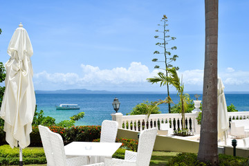Naklejka premium View from terrace over the ocean with some boats, carribean sea, beautiful view through plants