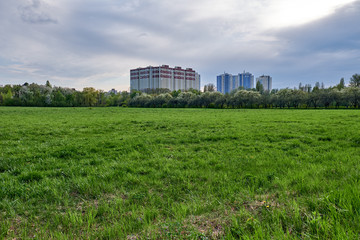 Fototapeta na wymiar Large modern residential building and green field 