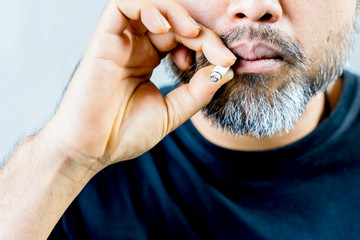 asian bearded man while smoking cigarette