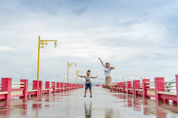 asian woman and little boy jumping with happiness . At Saran-way Bridge Prachuap Khiri Khan, thailand,