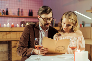 couple looking at menu during romantic dinner in restaurant