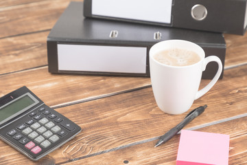 business desk with cup, calculator and pen