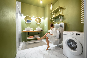 Beautiful loft interior bathroom with motion blurred woman in bathrobe sitting on the bowl