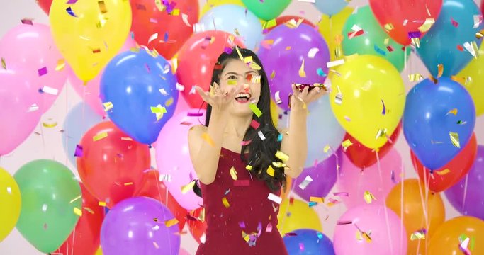 Beautiful asian woman dancing with happy emotion with colorful balloon background at the party in slow motion.