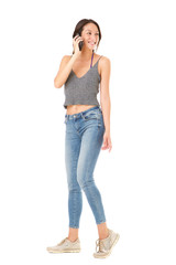 Full body smiling young asian woman talking on mobile phone against isolated white background