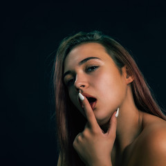 Obraz premium Young glamor beauty with long dyed hair sexually licks her finger.