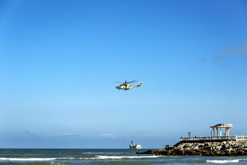 Fototapeta premium a helicopter over the sea and a gazebo with an inscription in Russian 