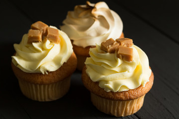 Gourmet cup cakes on textured background close up photo with selective focus