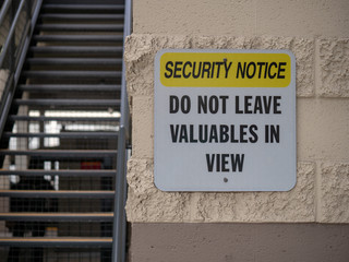 Security notice do not leave valuables in view street sign near parking lot