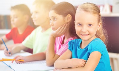 Smiling School Girl in the Classroom Using Tablet