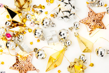 Christmas decorations, bows, stars,  bells in gold colors on white background . Holiday and celebration. Flat lay, top view