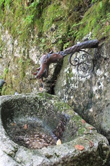 pipe spring in the form of a dragon's head of metal over a stone bowl