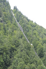 large funicular railway on the background of high mountains overgrown with green forest