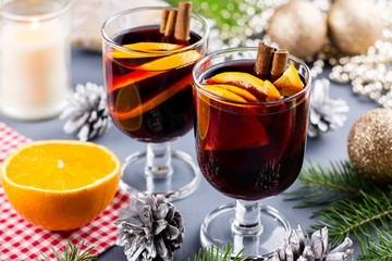 Two glasses of hot mulled wine with spices and sliced orange. Christmas drink with decorations.