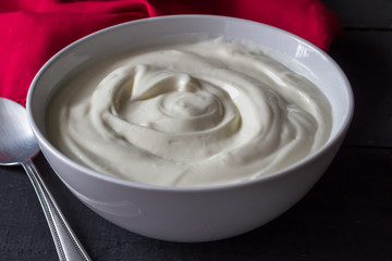Yogurt in bowl on rustic black table - Greek yogurt background