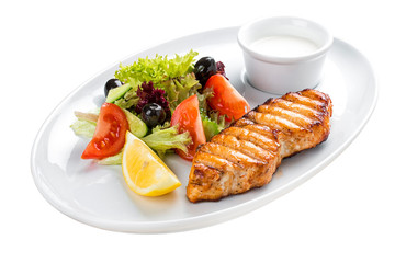 Grilled salmon steak with vegetables. On a white plate