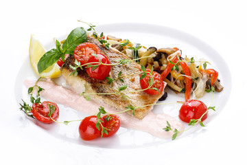 Pike perch with vegetables on a white dish.