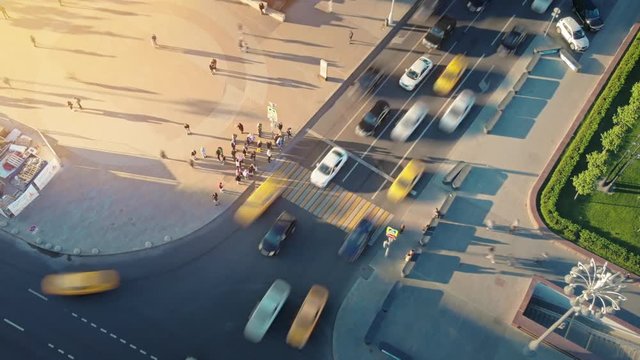 Motion timelapse of a busy Moscow crossroad on the evening, view from above. Aerial hyperlapse of urban scene of hard traffic moving and waiting at traffic lights and pedestrians crossing the road. 