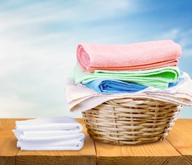 Laundry Basket with colorful towels on background