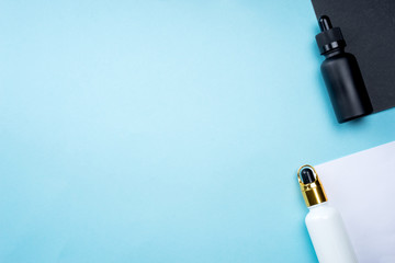 Cosmetic products arranged creatively on pastel colored background, flat lay view.