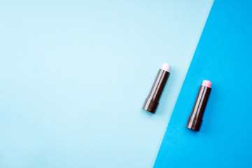 Cosmetic products arranged creatively on pastel colored background, flat lay view.