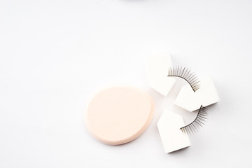 Cosmetic products arranged creatively on white background, flat lay view.