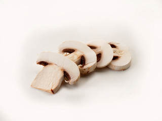 Un campiñón cortado en rodajas y apiladas sobre un fondo claro