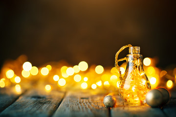 Merry Christmas and happy New year. Christmas garland in a glass jar on a wooden table. Selective focus.