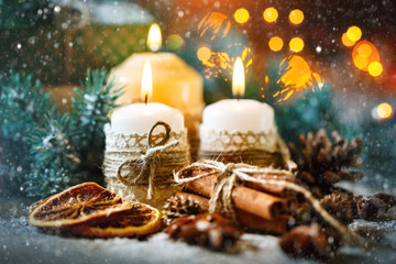 Merry Christmas and happy New year. Candle and Christmas toys on a wooden table. Bokeh. Selective focus.