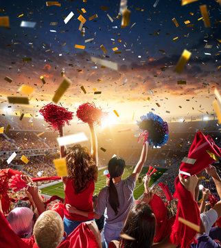 Young Sport Supporter Happy Fans At Stadium. Two Beautiful Women With Pompoms Support The Football Team During The Match