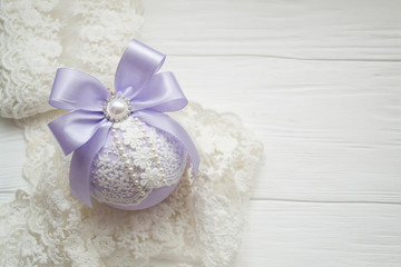 winter holiday decoration. Handmade Christmas tree toy decorated with satin purple ribbon, plastic flowers, pearls, lace.